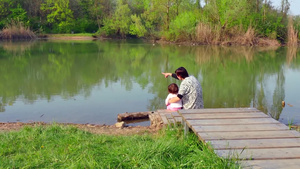 爸爸抱着孩子坐在水边看风景10秒视频