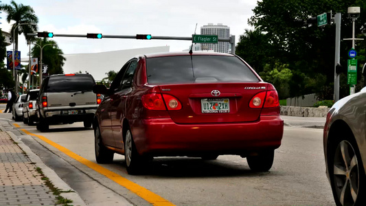 迈阿密市中心在一个红绿灯处的行驶的汽车视频