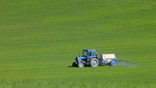 春天拖拉机在草地上喷涂农药视频