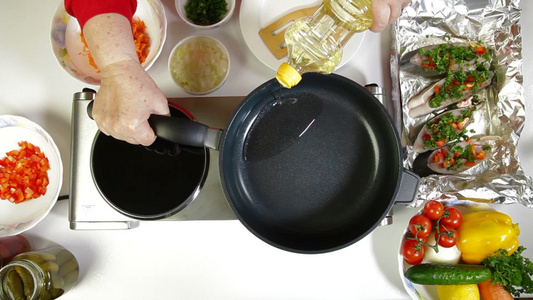 女性在煎锅上浇食用油视频