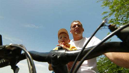 父亲和蹒跚学步的孩子骑自行车视频