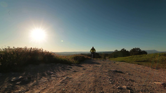 骑自行车的人在清晨沿着山路骑自行车[晨光熹微]视频