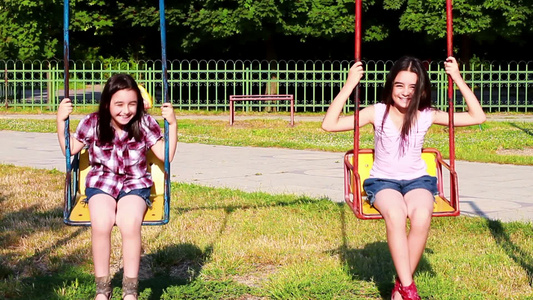 两个小女孩在公园里荡秋千视频