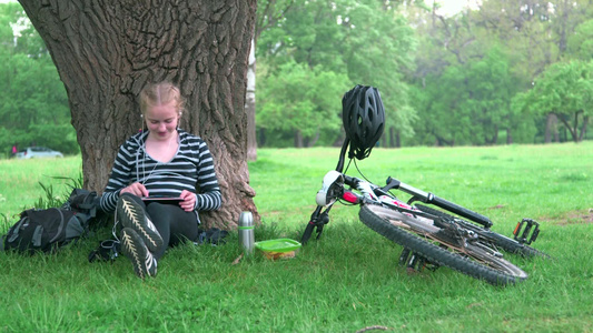 女孩在草地上使用平板电脑[绿茵茵]视频
