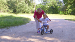 奶奶带孩子在公园骑自行车16秒视频