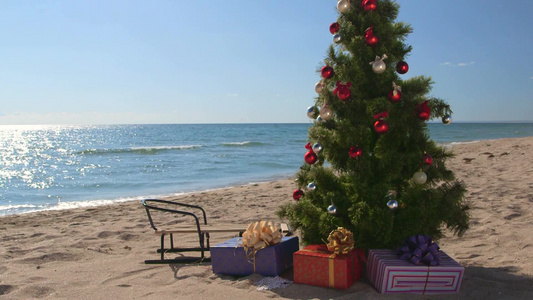 装饰圣诞树与礼品盒在沙滩上视频
