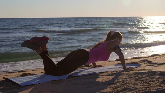 日落时在沙滩上健身的女孩视频