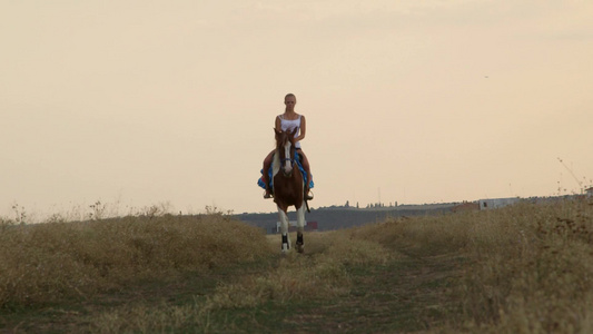 女子骑马穿过田野视频