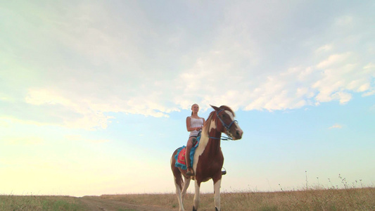 女孩骑马穿过田野视频