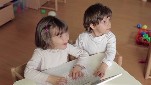 幼儿园的两个小朋友玩电脑视频