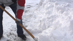 男人用铲子铲走道路上的雪19秒视频