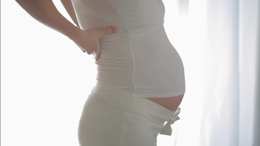 7个月的孕妇按摩她的背部视频