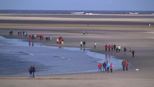 环绕着海滩散步的人群视频