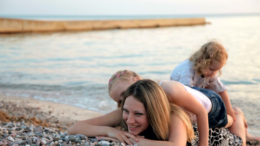 日落时母亲和两个女儿在海滩上视频
