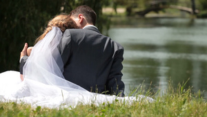 刚结婚的夫妇坐在池塘边拥抱13秒视频
