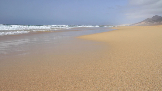 汹涌澎拜的海浪打到金色的沙滩上视频