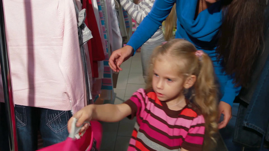 小女孩和她的家人在一家服装店里买衣服视频