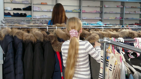 母女在一家服装店为女孩买衣服女孩在看衣服[几家]视频