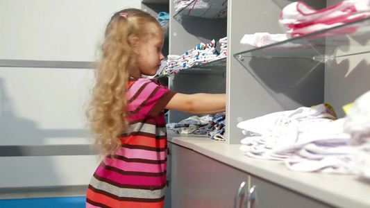 小女孩在一家服装店里挑选内衣[贴身衣服]视频