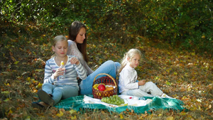 秋天里母亲和两个女儿在公园野餐14秒视频