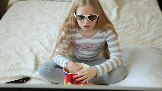 小金发女孩在家吃爆米花和看3D电视电影视频