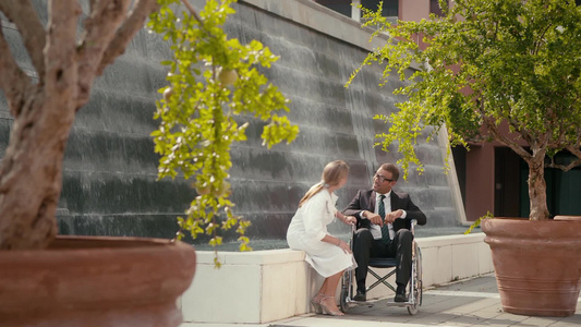医生在公园和坐轮椅的病人聊天视频