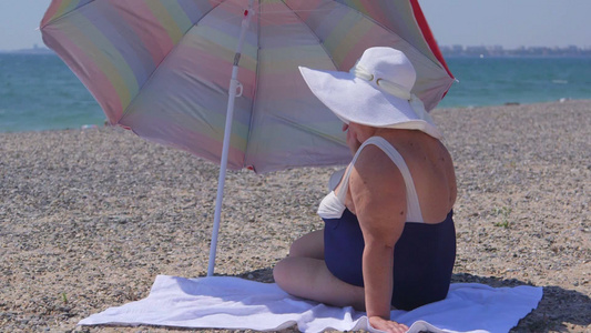 海滩上晒太阳的老妇人[地晒]视频