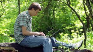 青少年坐在户外使用笔记本电脑13秒视频