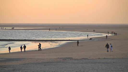 夕阳下在海边散步的人们[遛弯儿]视频