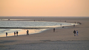 夕阳下在海边散步的人们11秒视频