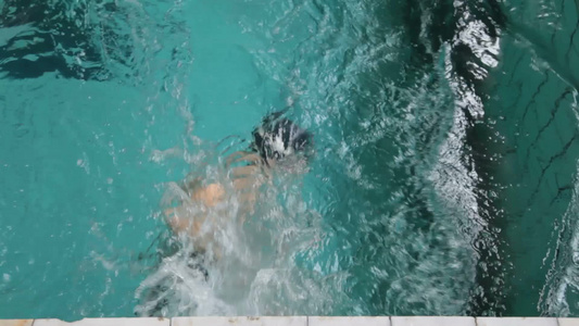 少年在游泳池里游泳视频