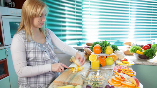 孕妇在厨房切橘子做水果沙拉视频