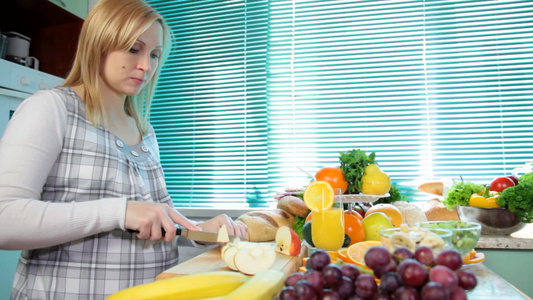 孕妇在厨房切苹果做水果沙拉视频