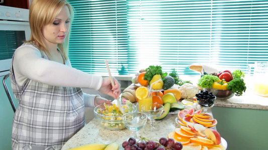 孕妇在厨房里混合水果沙拉视频