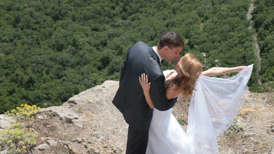 新娘和新郎在悬崖边拍婚纱照视频