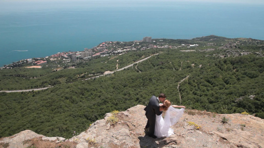 新娘和新郎在悬崖上拍婚纱照视频