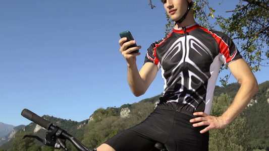 自行车运动员使用智能手机发短信[品牌手机]视频