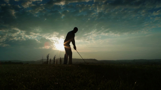  日落时打高尔夫的男人[黄昏时候]视频