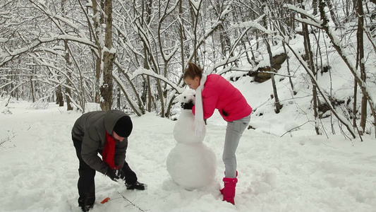 冬天夫妇在的雪林里堆雪人视频