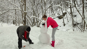 冬天夫妇在的雪林里堆雪人18秒视频