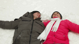 一对年轻夫妇躺在雪地上享受幸福的时光10秒视频