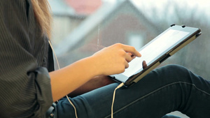 女孩坐在阳台上使用数字平板电脑听音乐12秒视频