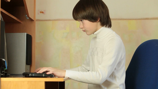 十几岁的男孩在家里玩桌面电脑游戏视频