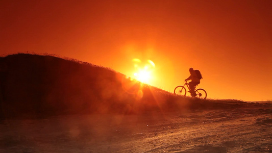 夕阳下骑自行车的运动员视频