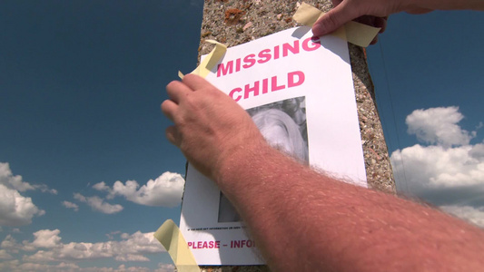在电线杆上张贴失踪儿童的照片视频