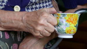老妇人双手捧着一杯茶特写29秒视频