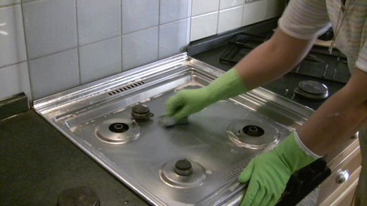 戴手套的女人清洁煤气炉视频