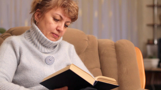 坐在扶手椅上看书的女人视频