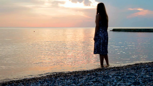 年轻的女人在海边的海滩上看日落19秒视频
