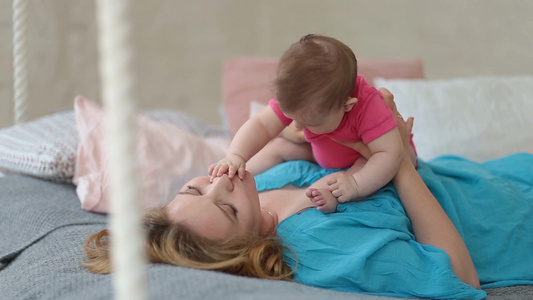 婴儿坐在妈妈的身上玩耍[幼婴]视频